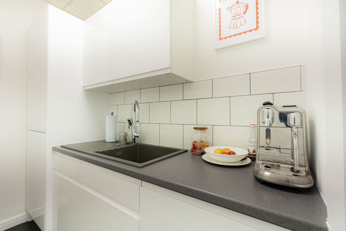 Fitted staff kitchen with tiled splashback and worktop